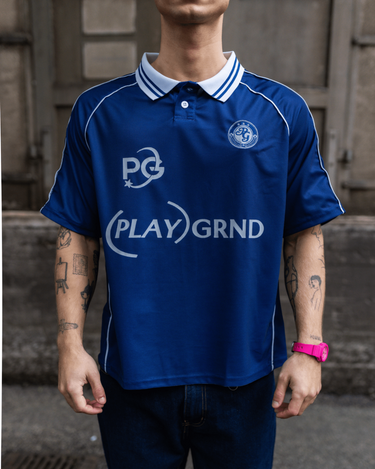 Mørkeblå PLAYGRND fodboldtrøje i polyester med hvid krave og logoer på brystet
